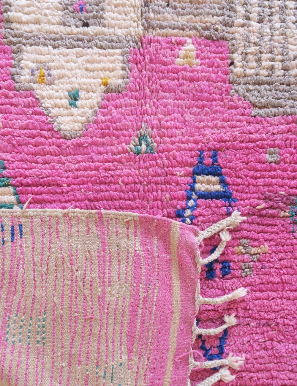 Close-up of a pink and white textured fabric with colorful patterns