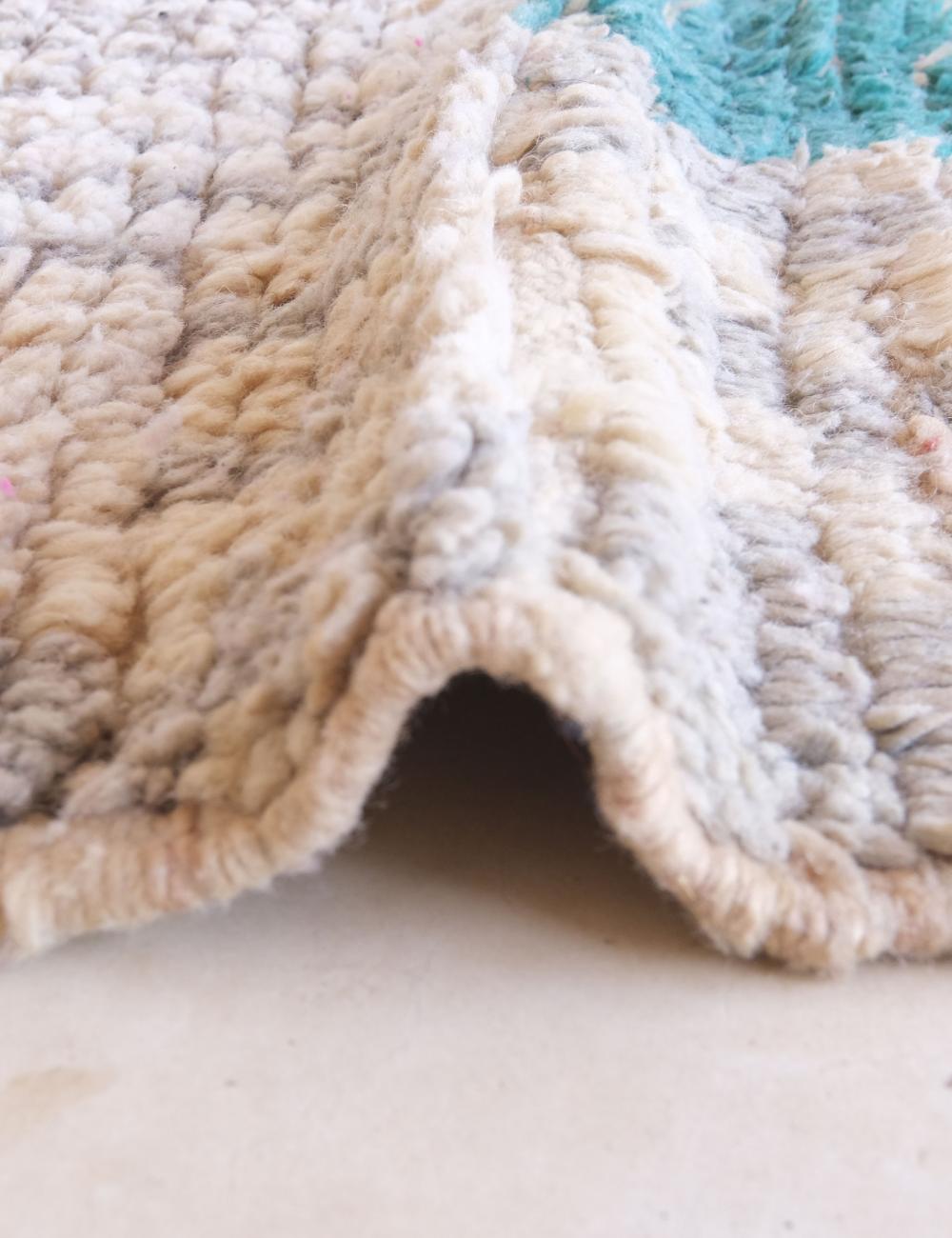 Close-up of a textured rug with a neutral color palette.